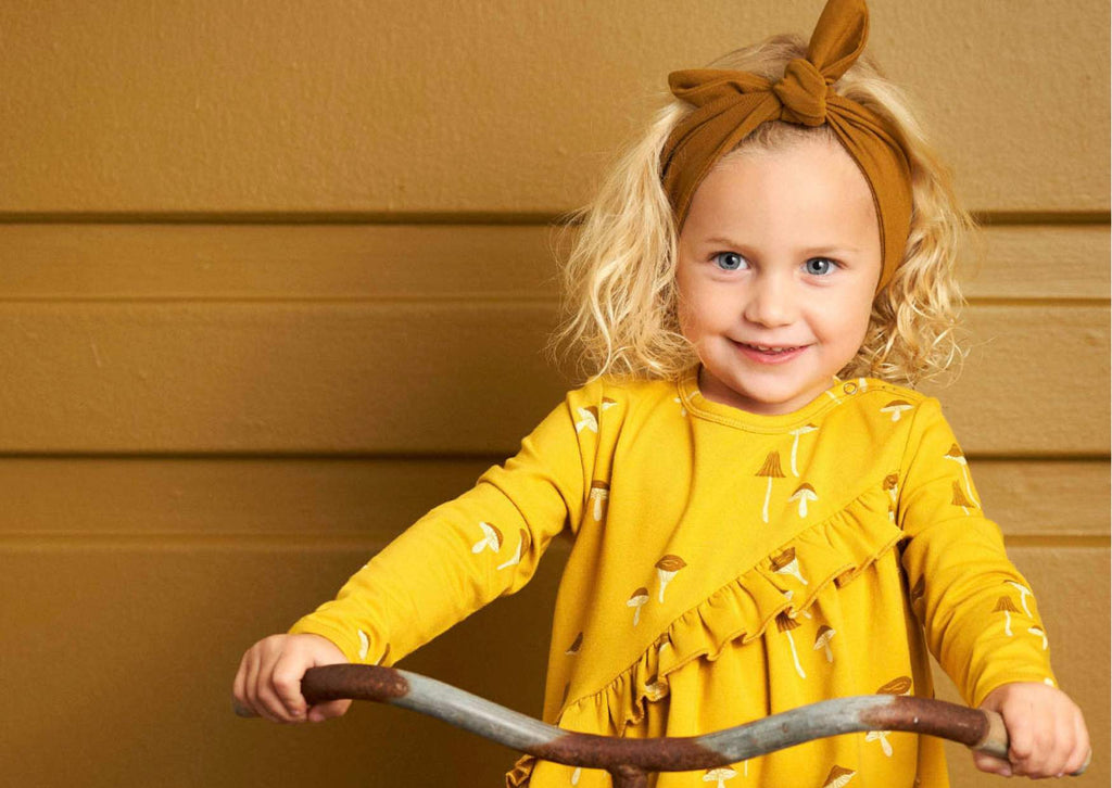 Little girl wearing Musli by Green Cotton organic cotton girls dress in yellow