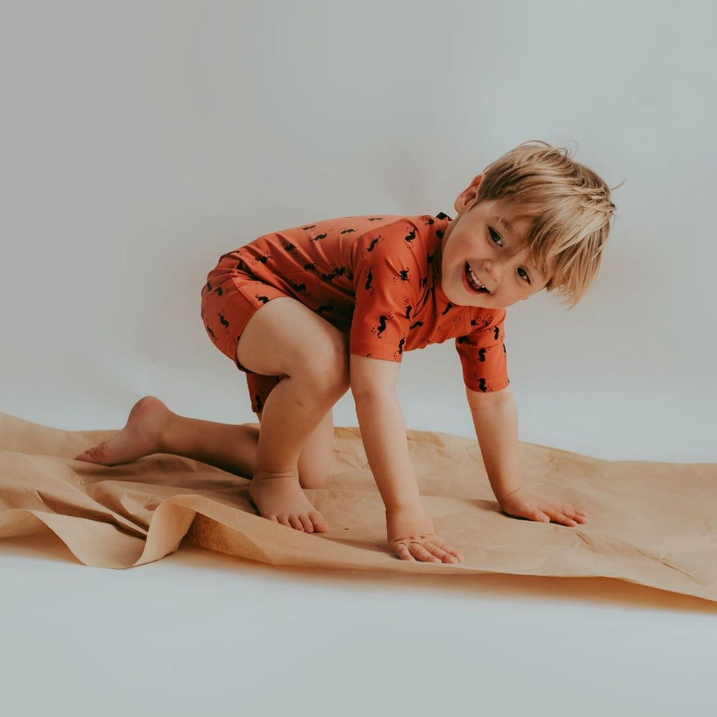 Boy in surfsuit made from recycled plastic