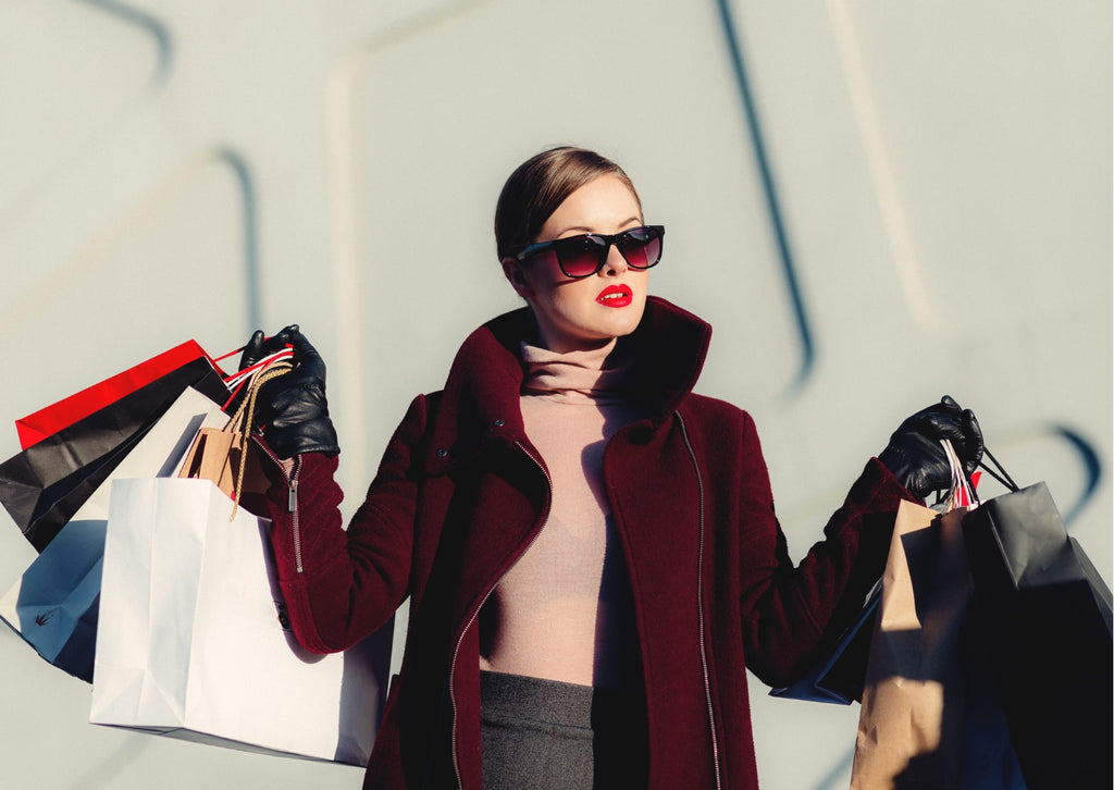 image of woman wearing sunglasses with lots of shopping bags