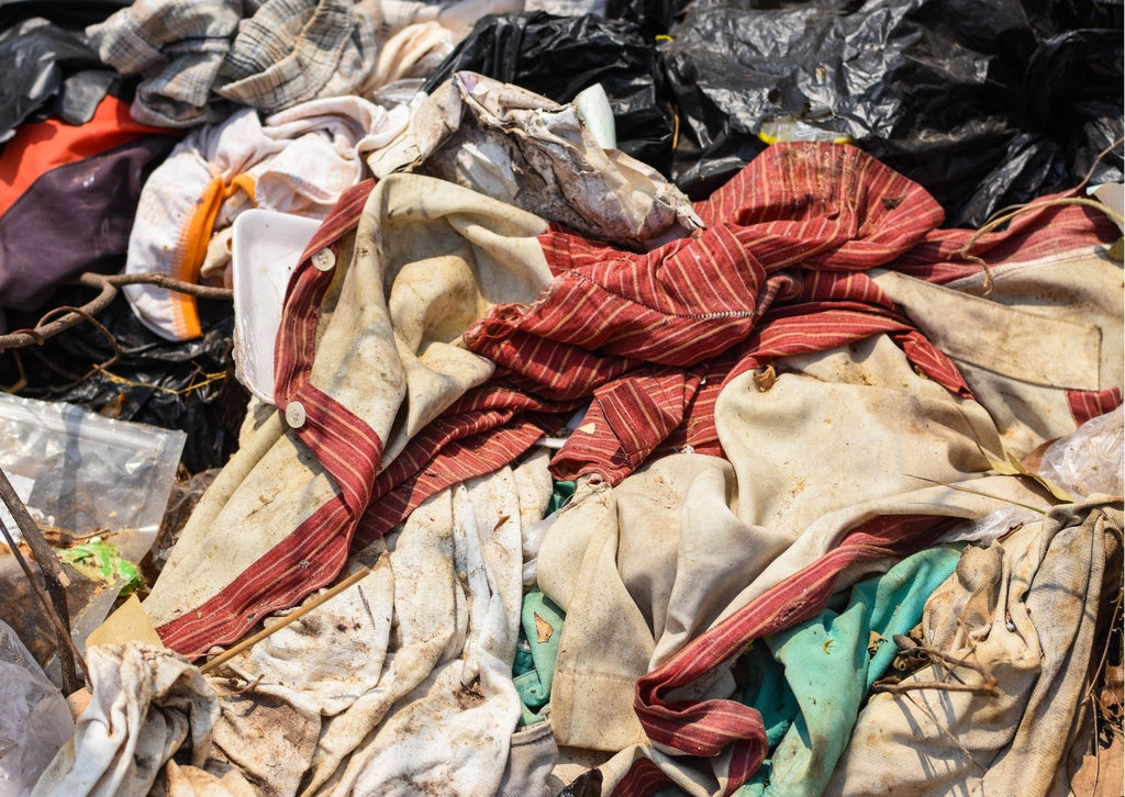 A heap of old used clothes in landfill