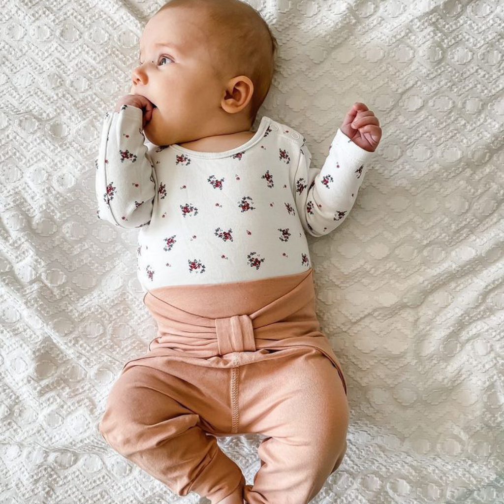 A baby girl wearing the Cozy Me Pretty Pants. Musli is one of the best sustainable baby brands in Europe.