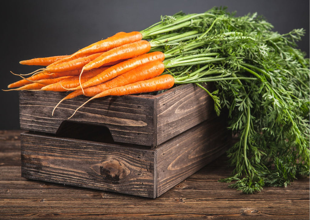 Organic carrots on top of a wooden crate