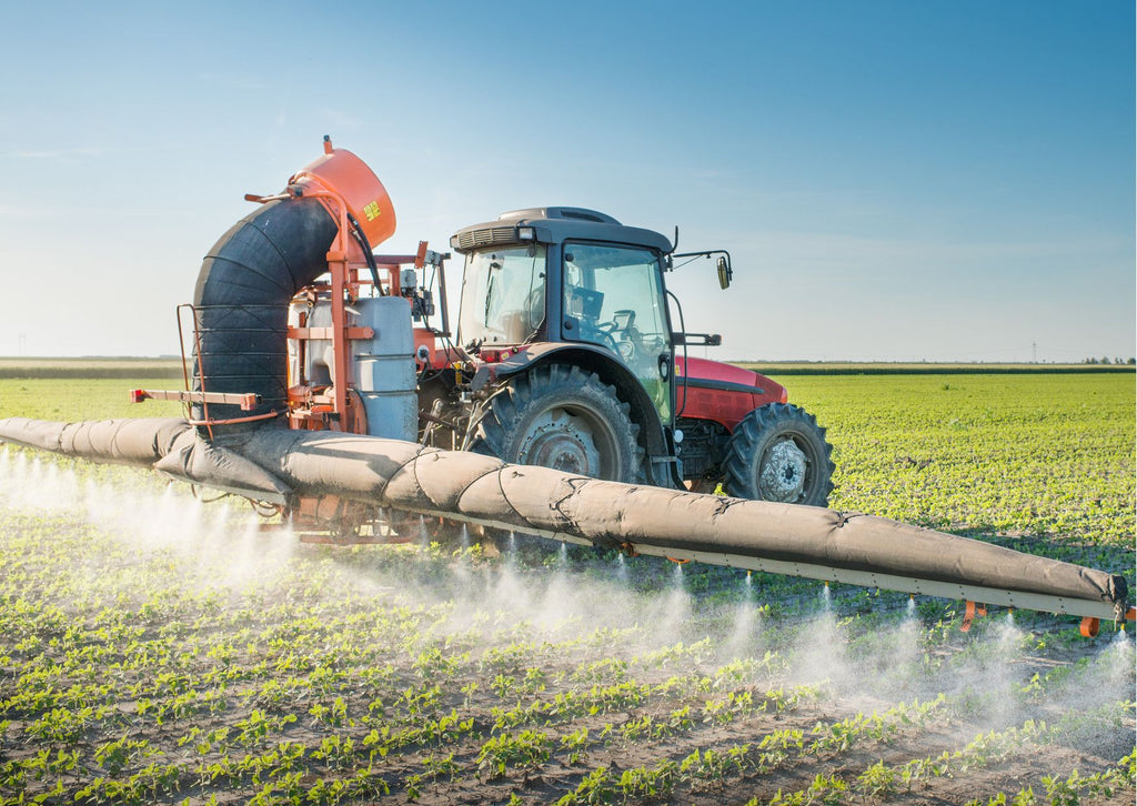 Tractor spraying chemicals on crops