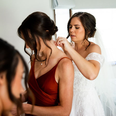 Bride putting pearl necklace on