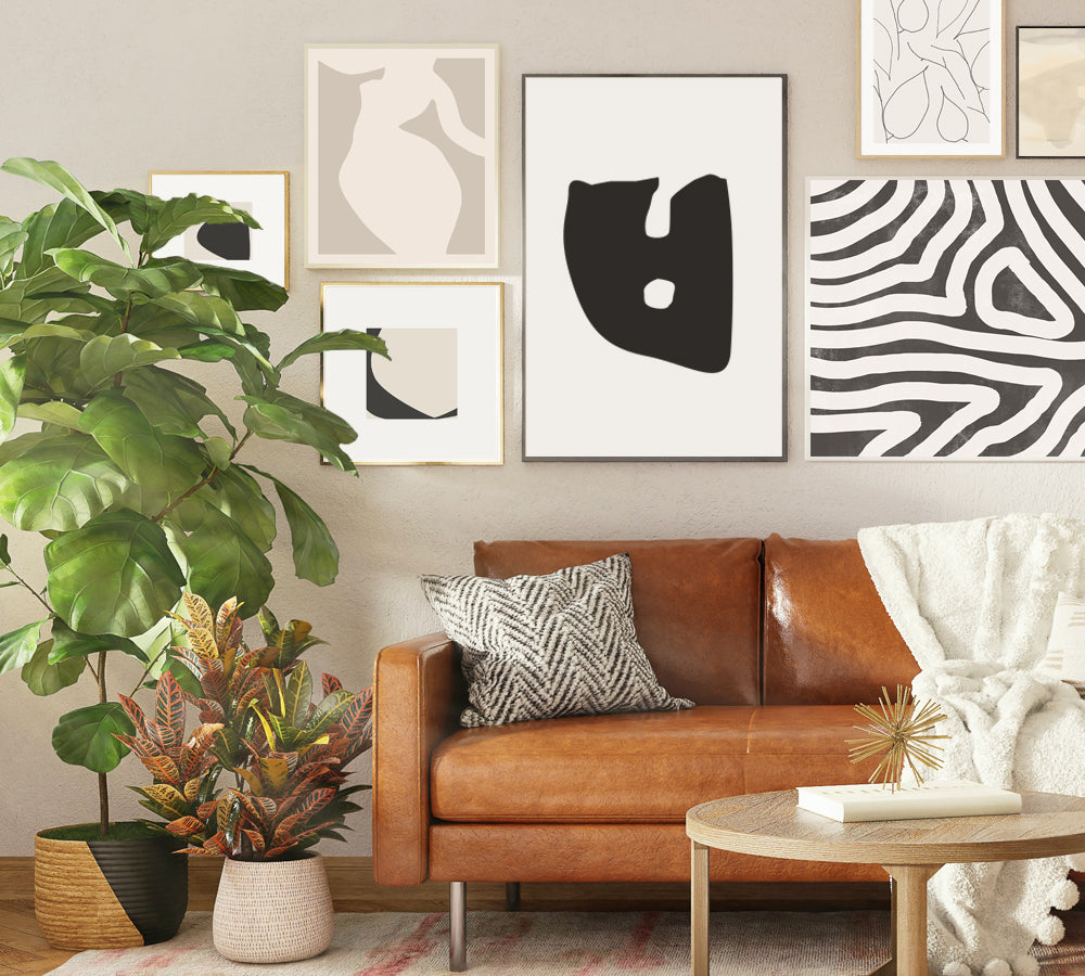 gallery wall, black and white abstract, Scandinavian design, leather sofa, large green plant