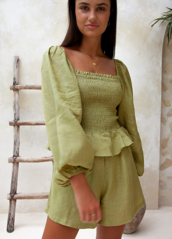 Model wearing the green playsuit from Palm Collective