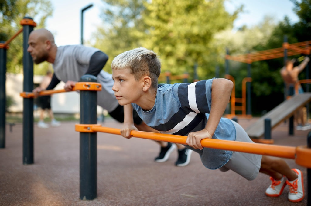 Father and son doing push up on the playground