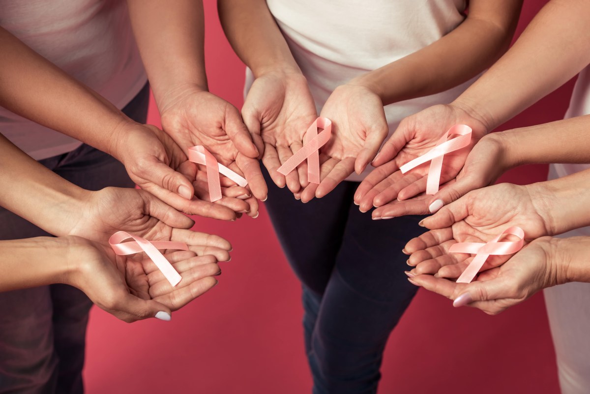 group of people in a circle showing a ribbon in their palms