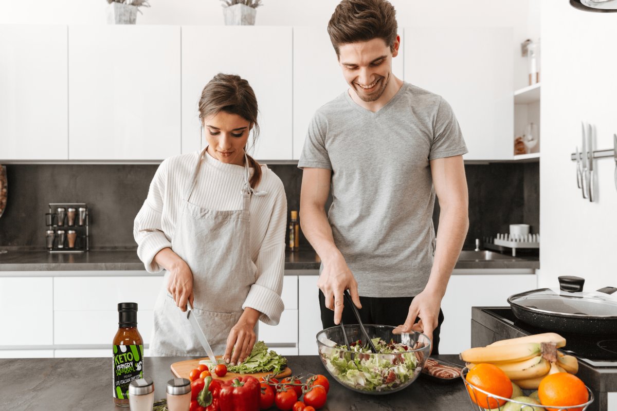 couple making a salad in their kitchen with hungry squirrel sauces