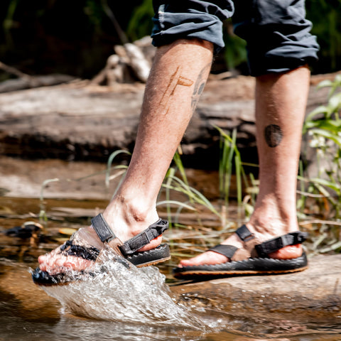 Man in sandals kicking water