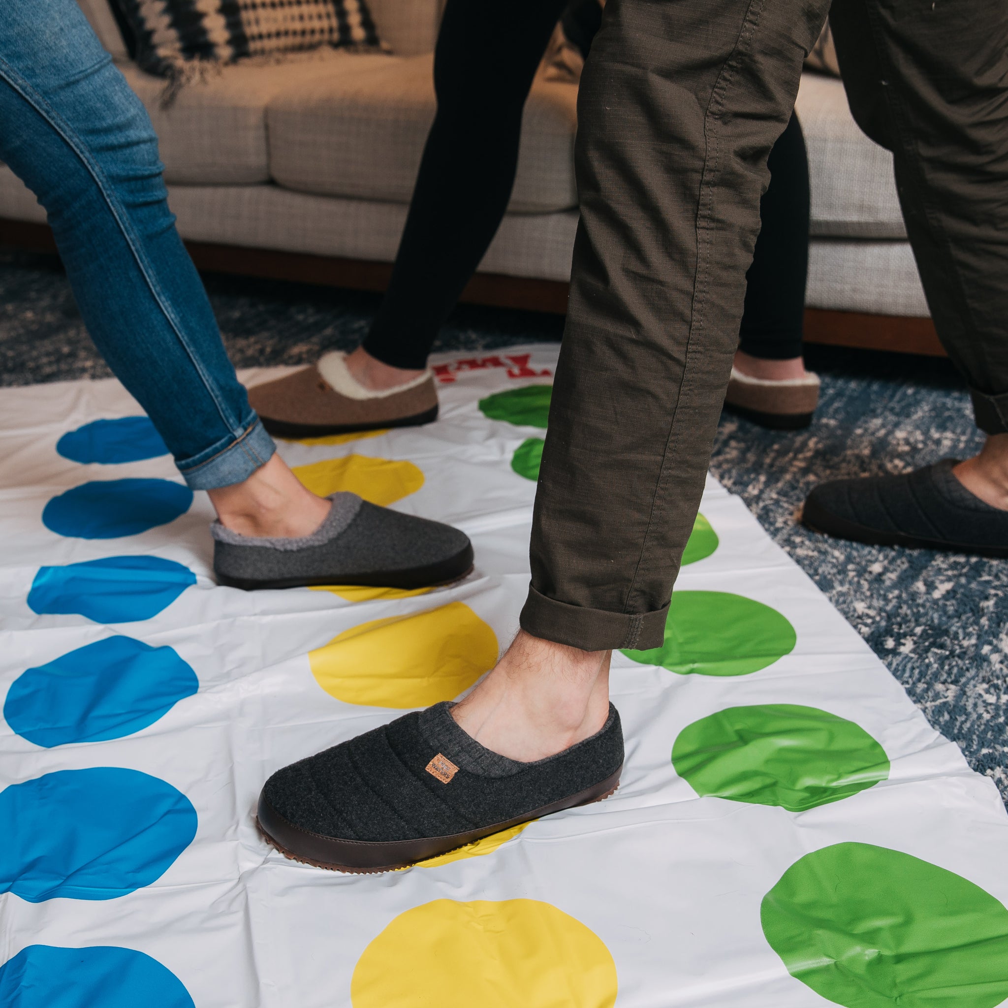 People playing twister the game with slippers on