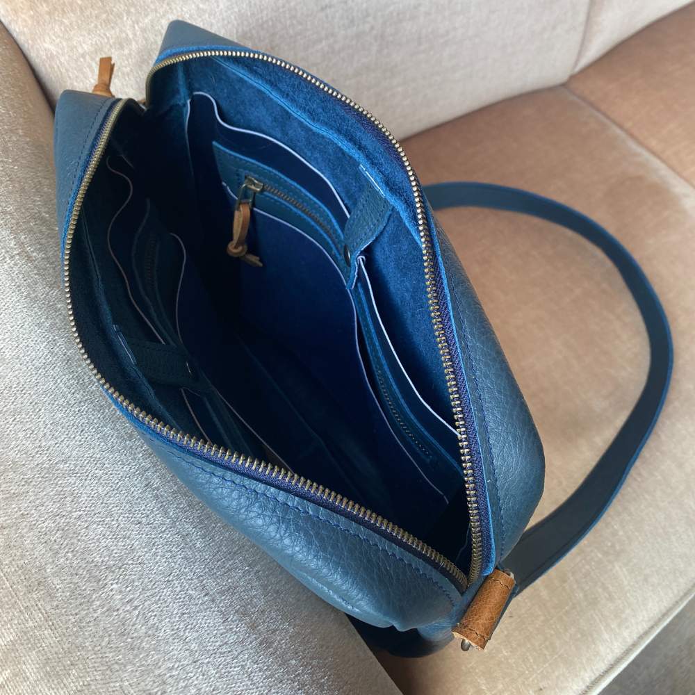 leren crossbody tas blauw, open vanaf bovenkant zodat je alle vakjes kan zien