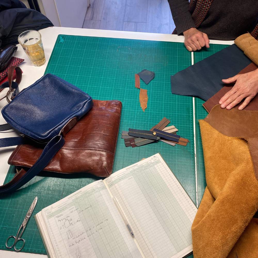 leren crossbody tas in blauw, overleg tijdens design date in het atelier