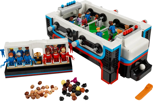 A playful LEGO rendition of a table football game, including minifigures as players in blue and red team uniforms.