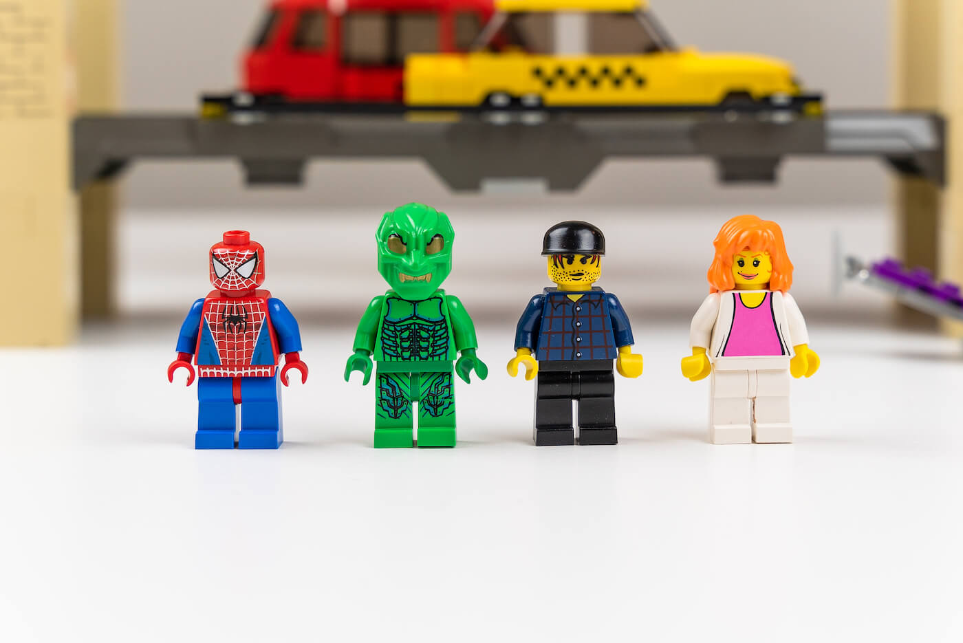 lego minifigures of spiderman, green goblin, a city worker, and Mary Jane Watson