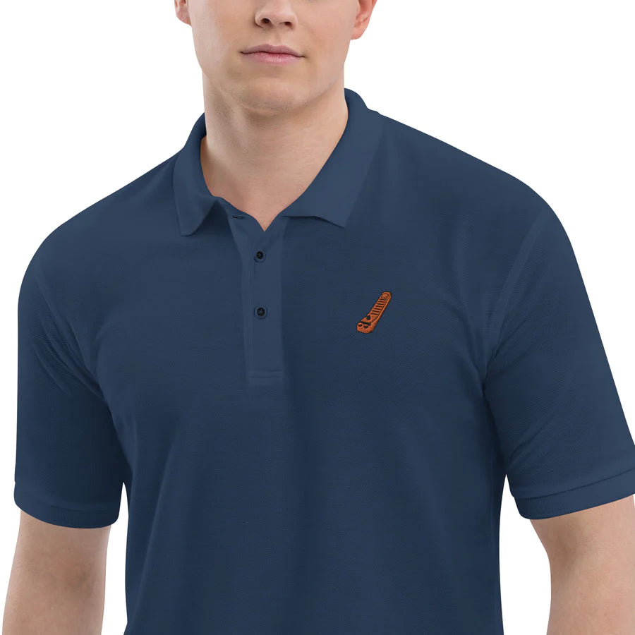 a male model wearing a blue polo shirt with a lego brick separator embroidered design