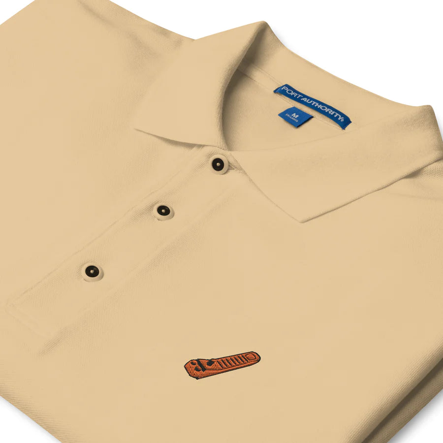 a khaki polo shirt with an orange embroidered brick separator
