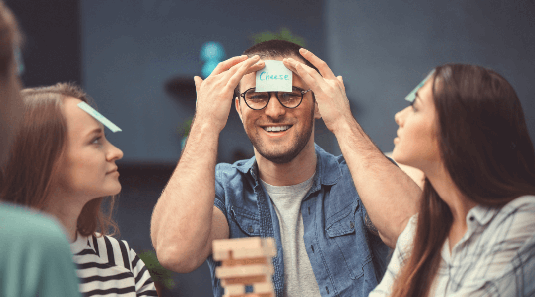 Adult friends playing Jenga game together. Smiling and happy.