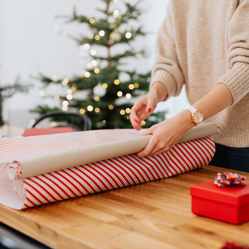 a person wrapping a Christmas gift