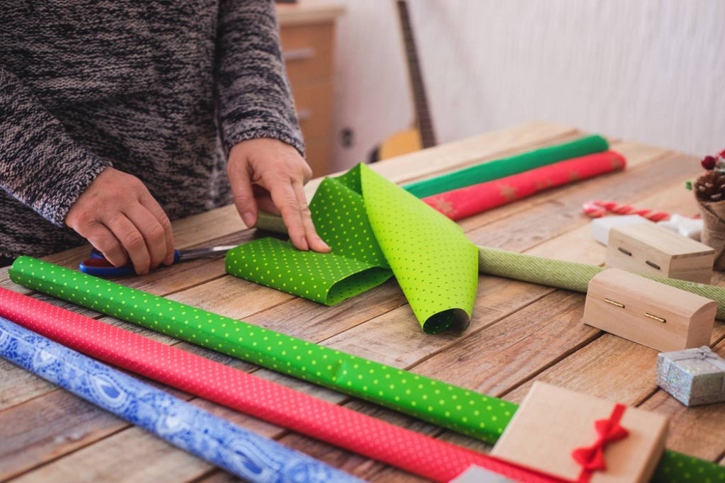 a person wrapping a present with decorative wrapping paper