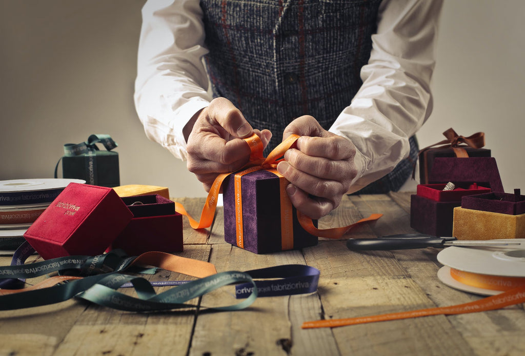 a person making a Christmas bow for a present
