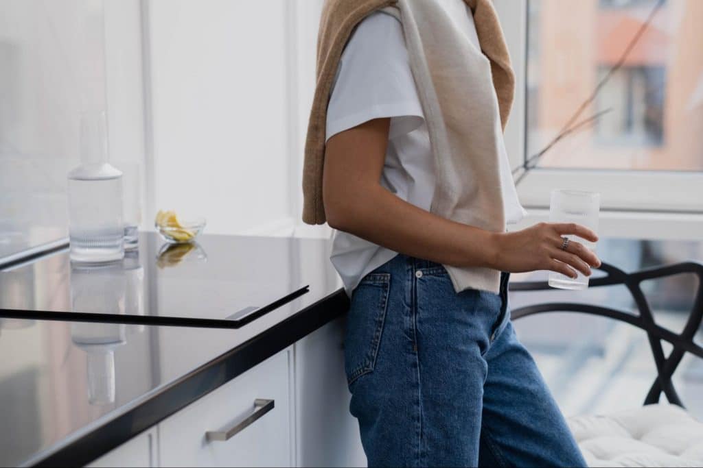 A healthy man takes his daily probiotic supplements in his kitchen