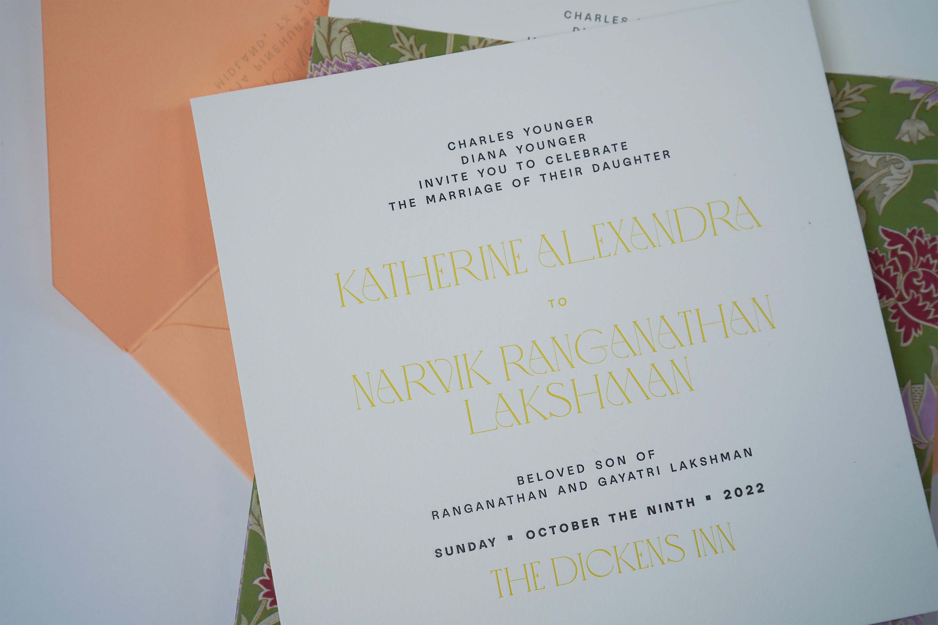 Letterpress wedding invitation with floral and peach envelope behind it