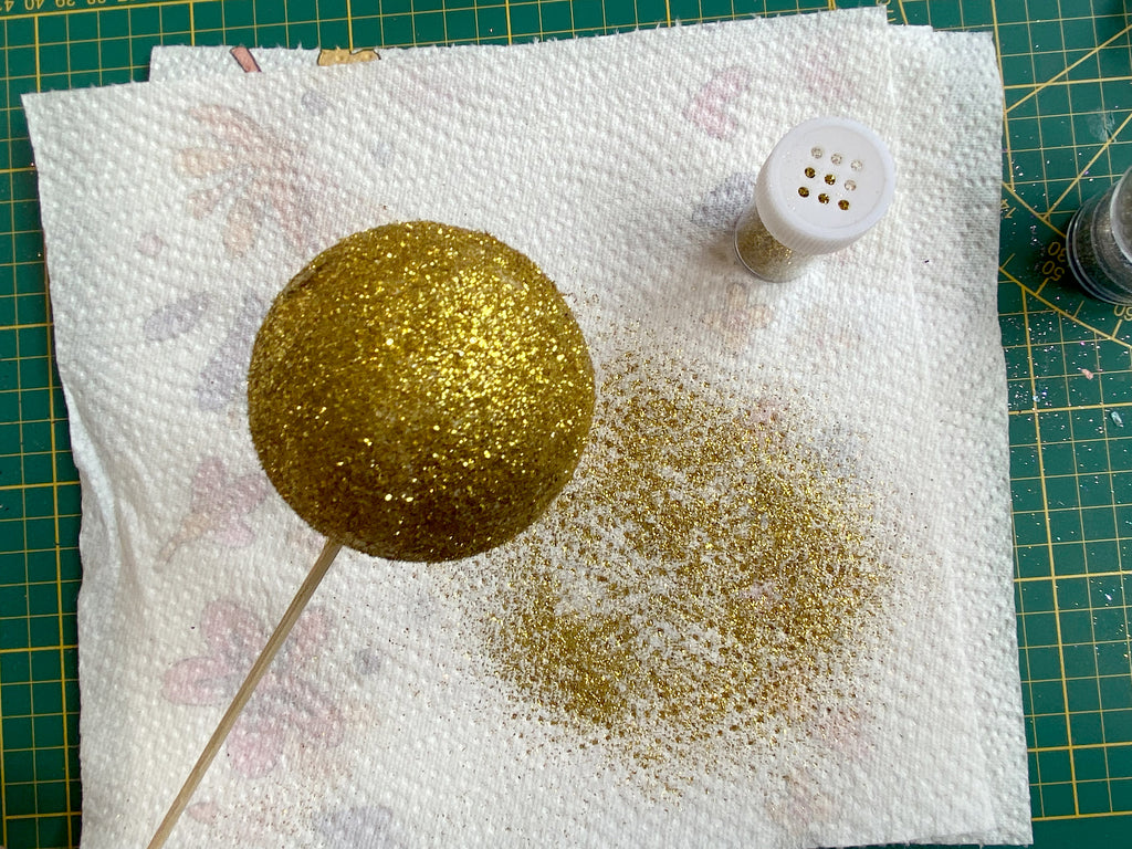 Styroporkugel ist komplett mit goldenem Glitzer bestreut