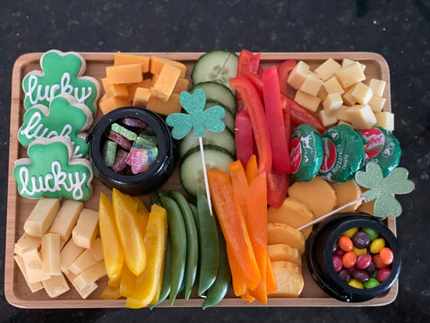 St Patricks Day shamrock charcuterie board with vegetables, cheese, candies and cookies