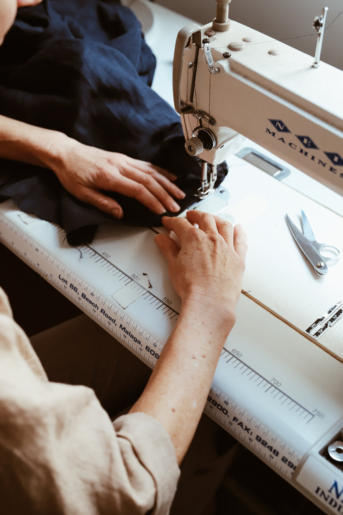 Kristin Magrit sits at her sewing machine making one of her designs.