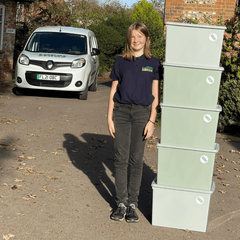 Francesca Hall stands behind a tower of Local Zero delivery boxes