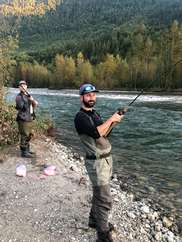 A Couple Fishing Together With A Rod By The Riverside Photo