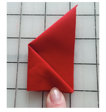red fabric triangle with the left point folded over to the right edge. Shown on a grided background.