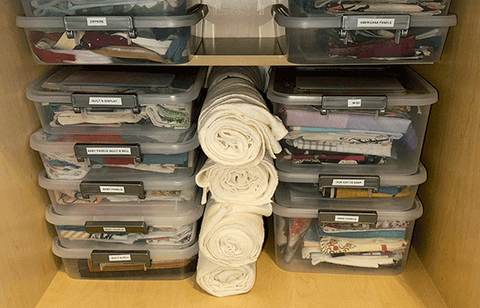 project cases in a cabinet with rolls of left over batting stored between them