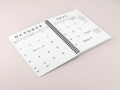 a spiral planner spread open on a pink background