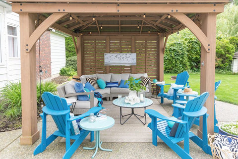beachy blue adirondack chairs and blue pillows and accessories matching grey in the backyard
