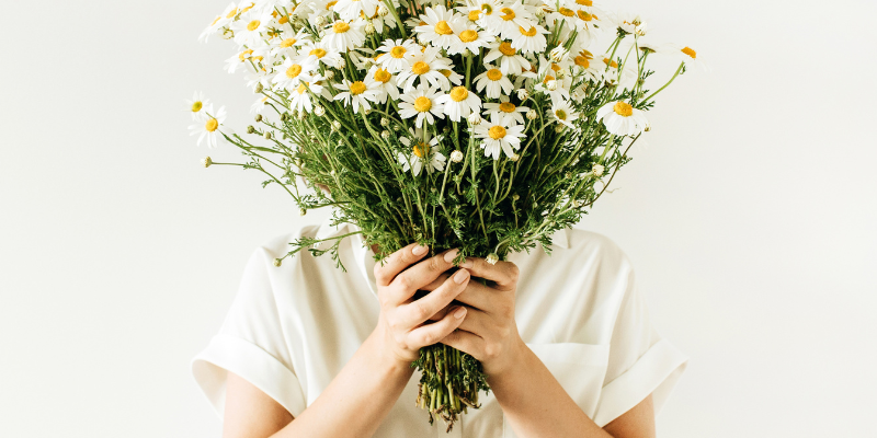 Woman holding organic bunch of flowers in front of her face