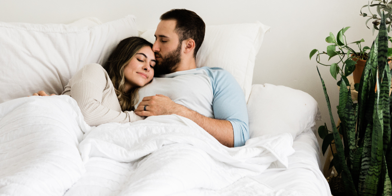 Couple embracing in bed after childbirth