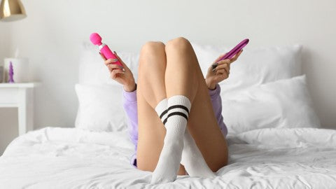 Women lying on back holding vibrator