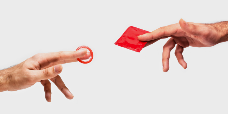 Hands holding red condoms