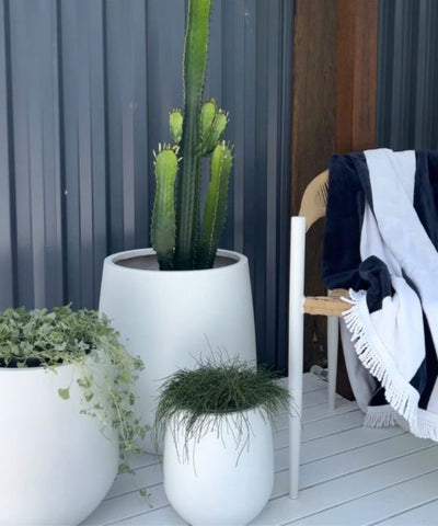 White pot planters interconnect with the white decking for a soft, minimalist feel.