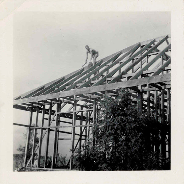 woman builder on roof of house frame