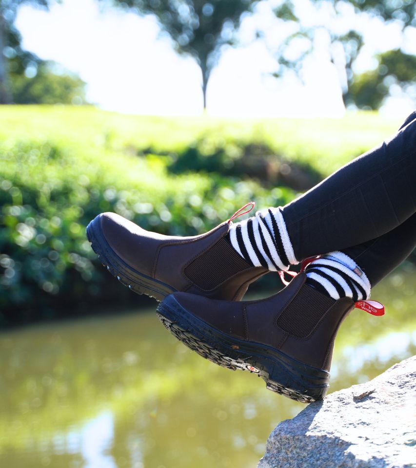 brown womens work boots next to a creek