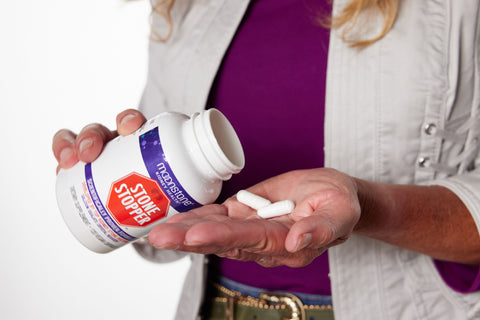 A person holding an alkali citrate kidney stone supplement called Moonstone Stonestopper