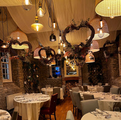 Photo showing willow hearts decorated with flowers. They are hanging from the ceiling of Ronnie's Restaurant.