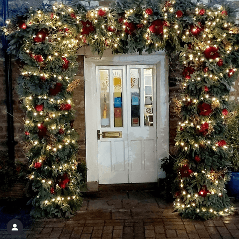 Photo showing an exterior, Christmas arch with fairy lights outside the entry to Ronnie's Restaurant.