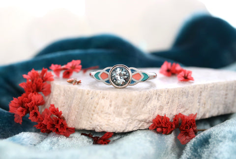 A teal sapphire engagement right with teal and coral enamel