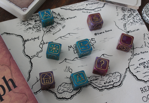 8 cartograph dice scattered across a handdrawn map