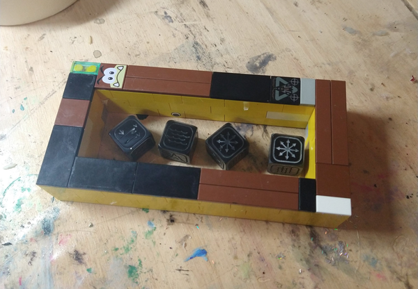 A box of lego encasing 4 master dice ready for mold making