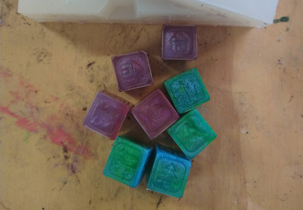A collection of 4 blue-green dice and 4 purple-pink dice